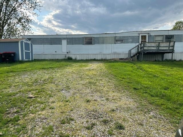 back of property with an outdoor structure, a yard, and a shed