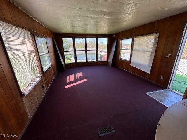unfurnished sunroom featuring visible vents and a wealth of natural light