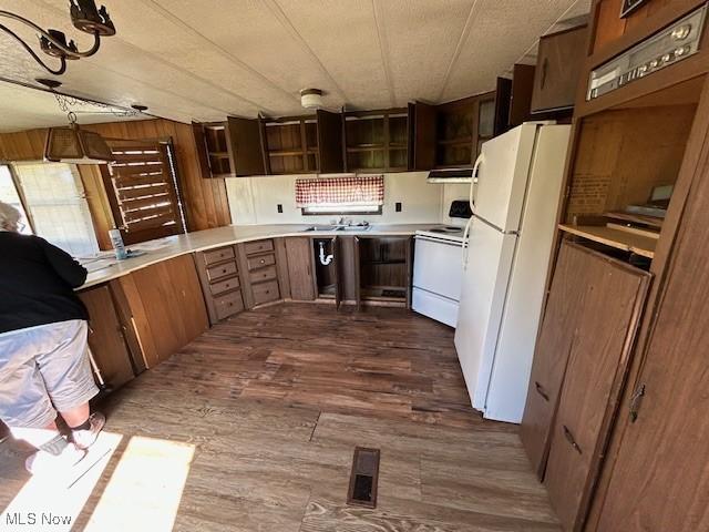 kitchen featuring light countertops, dark wood-style flooring, white appliances, and ventilation hood