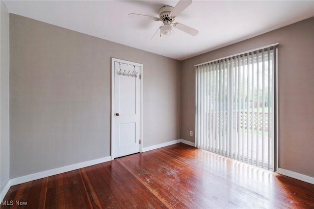 spare room featuring baseboards, ceiling fan, and wood-type flooring