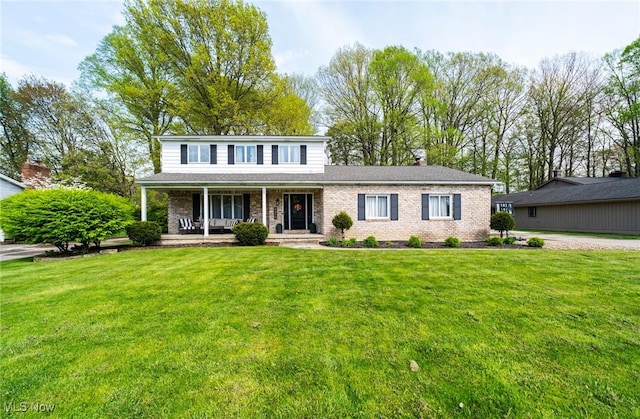 8459 Four Seasons Trl, Poland, OH 44514 - traditional home with brick siding, a chimney, a front yard, and a porch