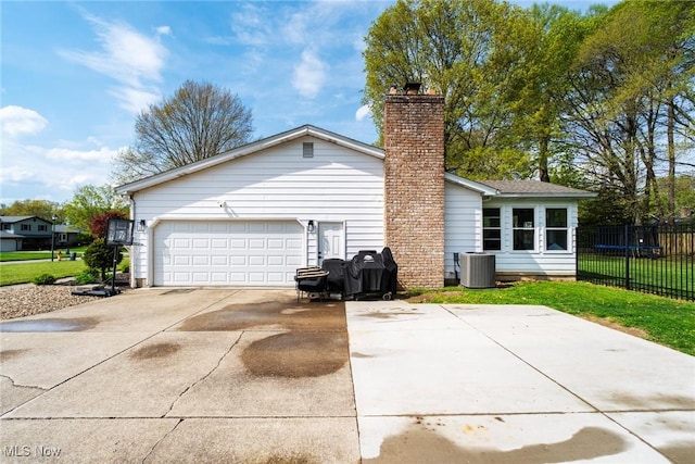 8459 Four Seasons Trl, Poland, OH 44514 - view of property exterior featuring driveway, a chimney, a garage, cooling unit, and fence