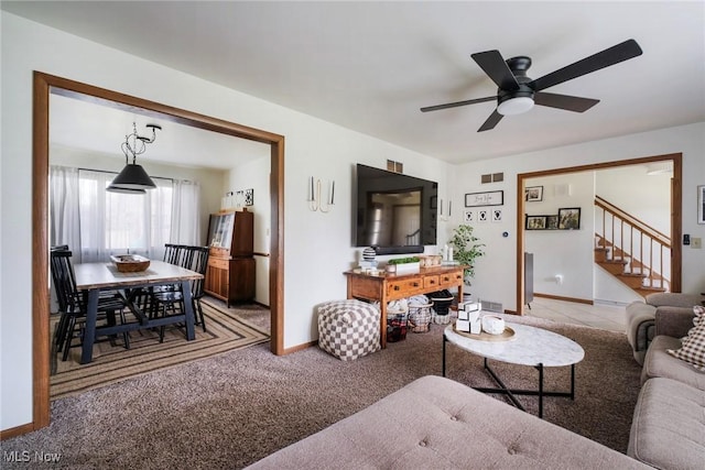 8459 Four Seasons Trl, Poland, OH 44514 - living area with visible vents, stairs, light carpet, baseboards, and ceiling fan