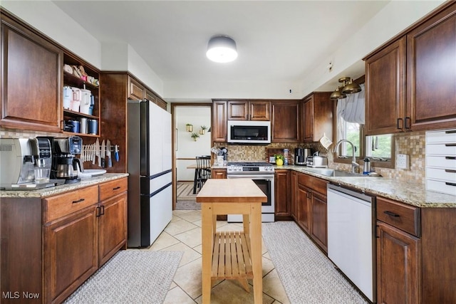 8459 Four Seasons Trl, Poland, OH 44514 - kitchen with freestanding refrigerator, white dishwasher, gas range, tasteful backsplash, and a sink