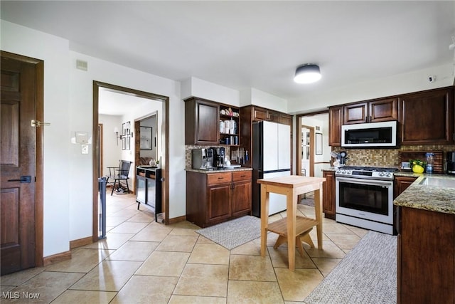 8459 Four Seasons Trl, Poland, OH 44514 - kitchen featuring dark brown cabinets, stainless steel range with gas cooktop, freestanding refrigerator, decorative backsplash, and white microwave