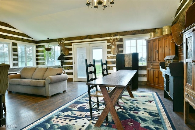 interior space with a chandelier, lofted ceiling, and dark wood-style floors