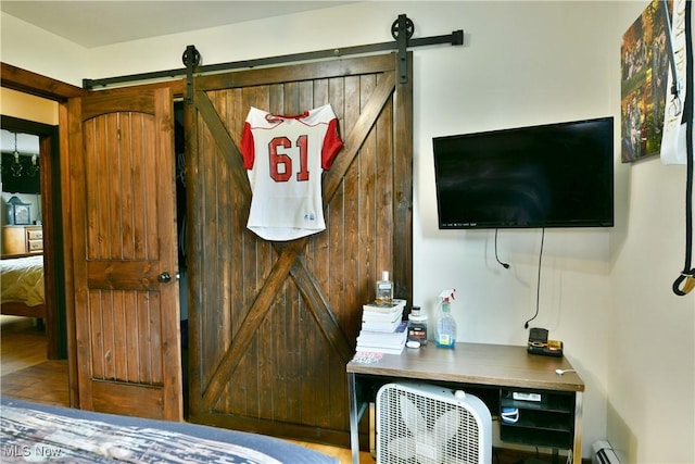 bedroom with a barn door and baseboard heating