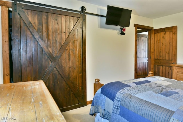carpeted bedroom with a barn door