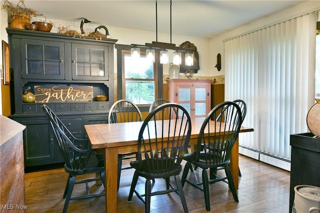 dining area with dark wood-style flooring and baseboard heating