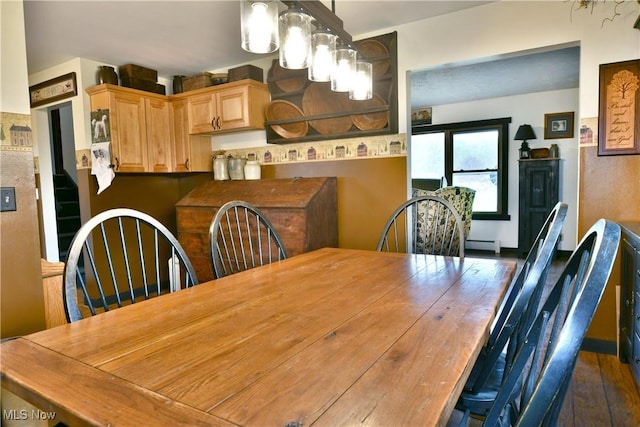 dining space with a baseboard heating unit and dark wood-style floors