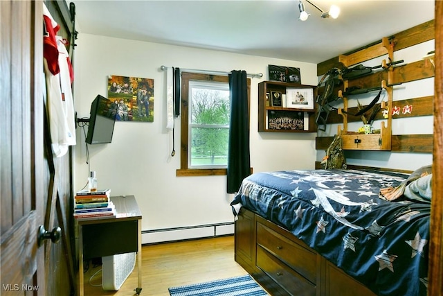 bedroom featuring wood finished floors and baseboard heating
