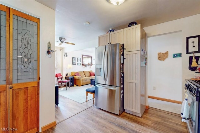 kitchen with baseboards, open floor plan, ceiling fan, light wood-type flooring, and appliances with stainless steel finishes