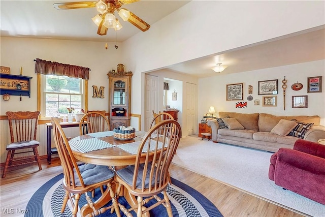 dining space with ceiling fan and light wood-style flooring