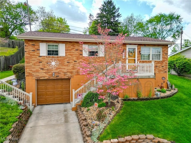 view of front of home with a garage, a front lawn, fence, brick siding, and concrete driveway
