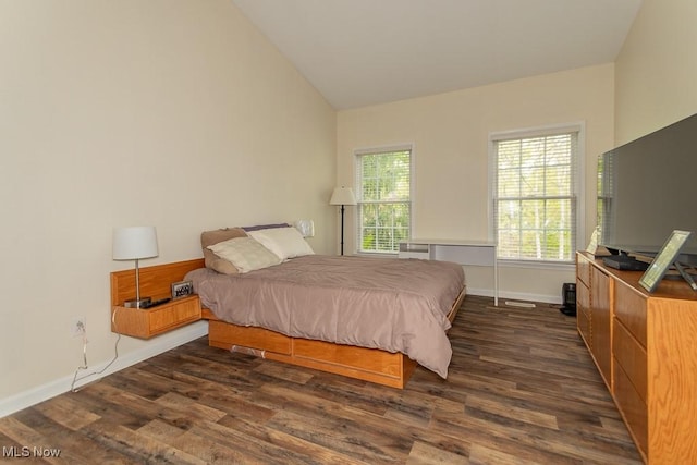 bedroom with dark wood-type flooring, baseboards, and vaulted ceiling