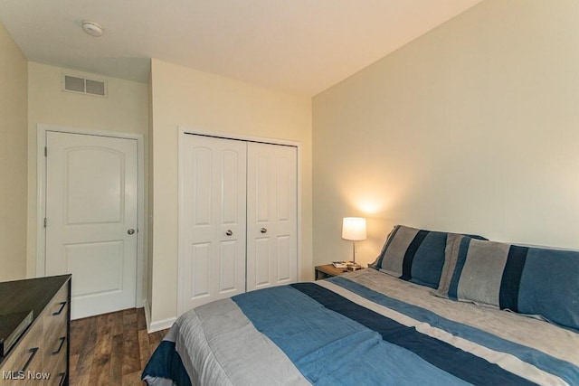 bedroom featuring a closet, baseboards, visible vents, and dark wood-type flooring