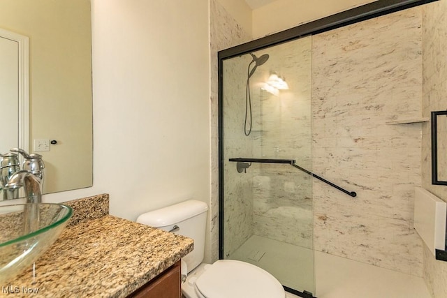 bathroom featuring vanity, toilet, and tiled shower