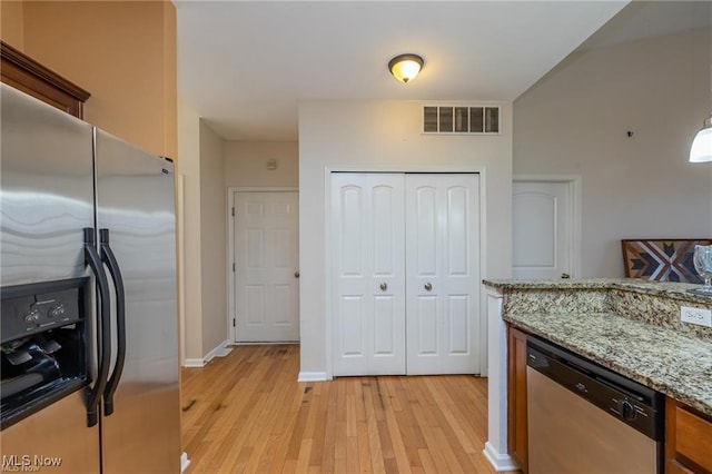 kitchen with visible vents, light stone countertops, baseboards, light wood-style flooring, and appliances with stainless steel finishes