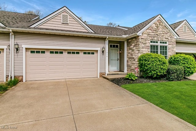 view of front of home featuring a garage, concrete driveway, roof with shingles, and stone siding