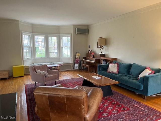 living area with ornamental molding, a wall mounted AC, and hardwood / wood-style flooring