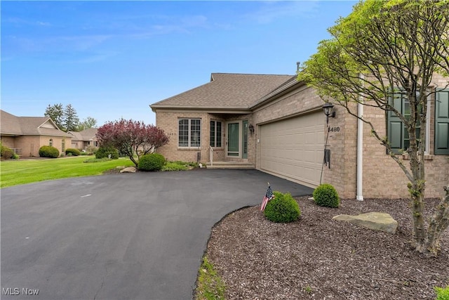 ranch-style house featuring brick siding, driveway, a front lawn, and a garage