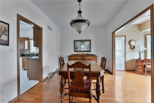dining room with visible vents, a wealth of natural light, and light wood finished floors