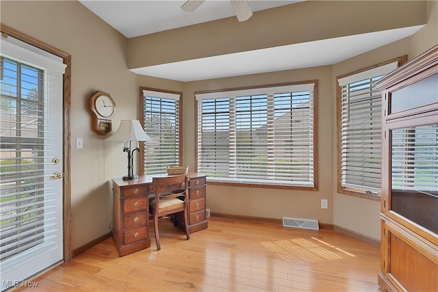 office area with baseboards, a ceiling fan, light wood finished floors, and visible vents
