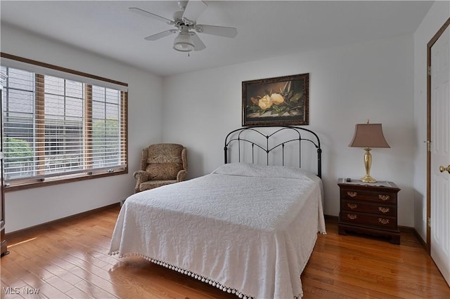 bedroom with baseboards, a ceiling fan, and wood finished floors