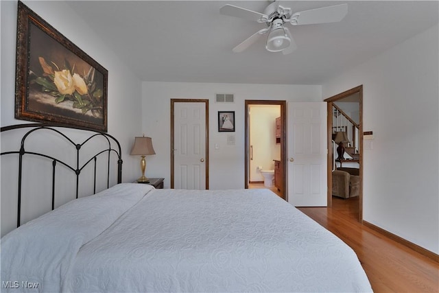 bedroom featuring visible vents, wood finished floors, baseboards, connected bathroom, and a ceiling fan