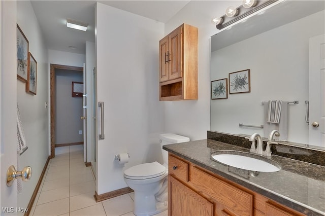 bathroom featuring tile patterned floors, baseboards, vanity, and toilet