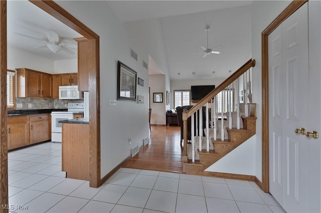 kitchen featuring dark countertops, ceiling fan, white appliances, and visible vents