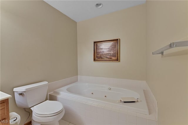 bathroom with vanity, toilet, and a tub with jets