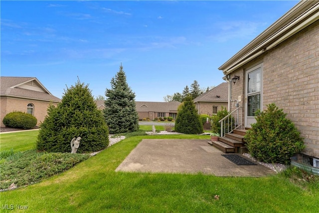 view of yard featuring entry steps and a patio area