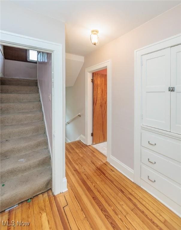 stairs with baseboards and wood finished floors
