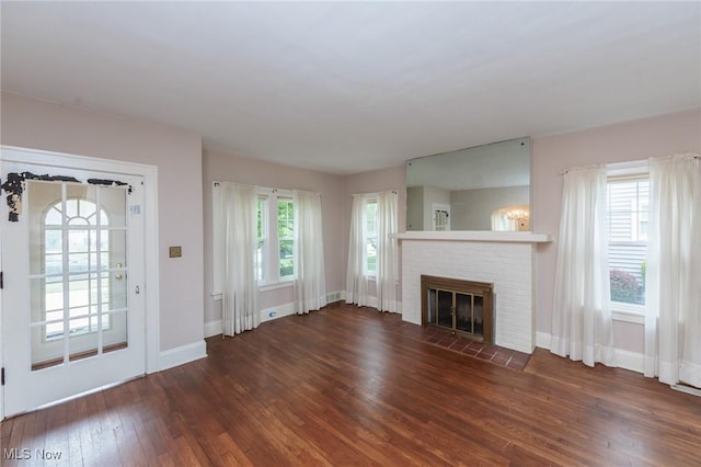 unfurnished living room with a fireplace, baseboards, and wood-type flooring