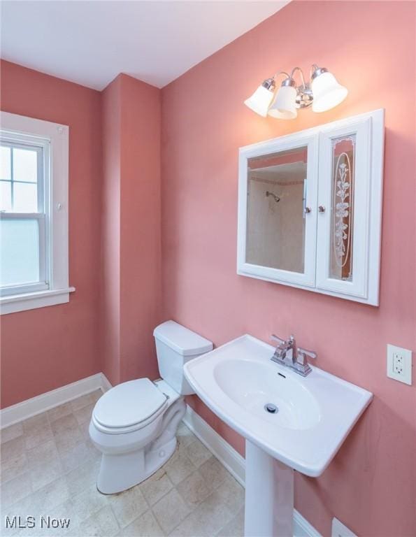 bathroom with baseboards and toilet