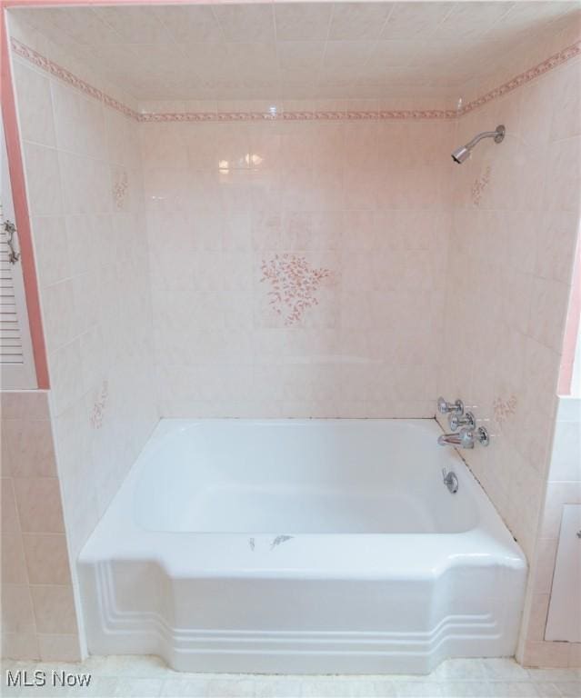 full bathroom featuring shower / bath combination and tile walls