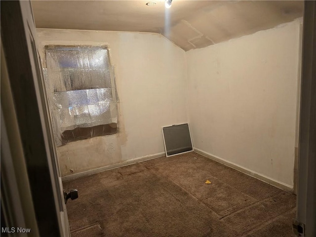 carpeted spare room with vaulted ceiling