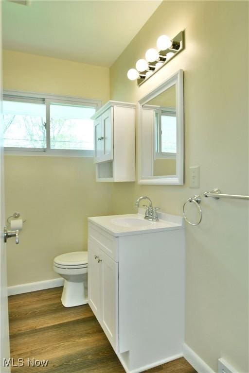 5071 Copeland Ave NW, Warren, OH 44483 - half bathroom with vanity, baseboards, toilet, and wood finished floors