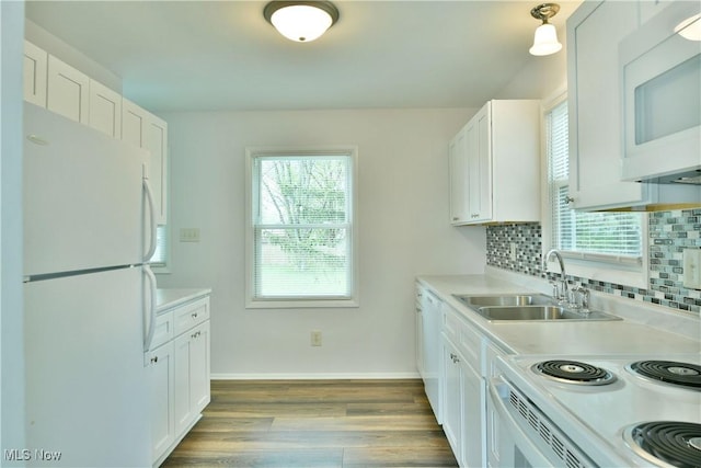 5071 Copeland Ave NW, Warren, OH 44483 - kitchen featuring wood finished floors, white appliances, light countertops, a sink, and backsplash