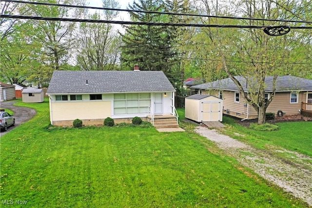 5071 Copeland Ave NW, Warren, OH 44483 - view of front facade featuring driveway, a chimney, a storage shed, an outbuilding, and a front lawn