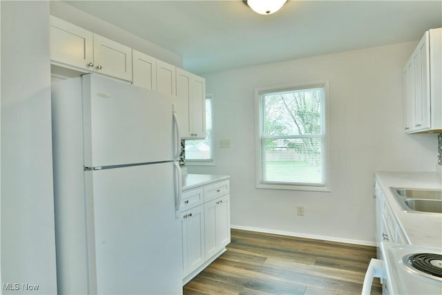 5071 Copeland Ave NW, Warren, OH 44483 - kitchen featuring range, dark wood finished floors, light countertops, freestanding refrigerator, and white cabinetry