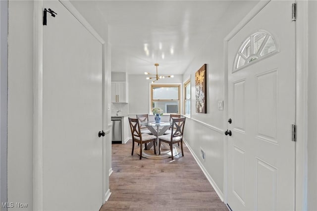interior space featuring an inviting chandelier and light wood finished floors