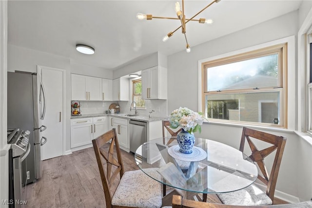 dining area with light wood finished floors and a chandelier