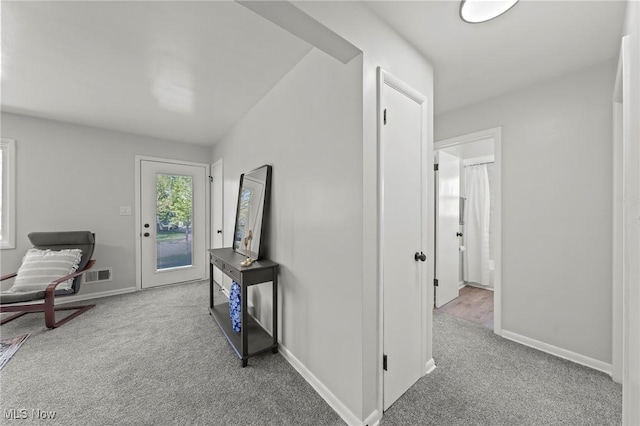 corridor with baseboards, carpet, and visible vents
