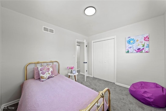 carpeted bedroom with visible vents, baseboards, and a closet