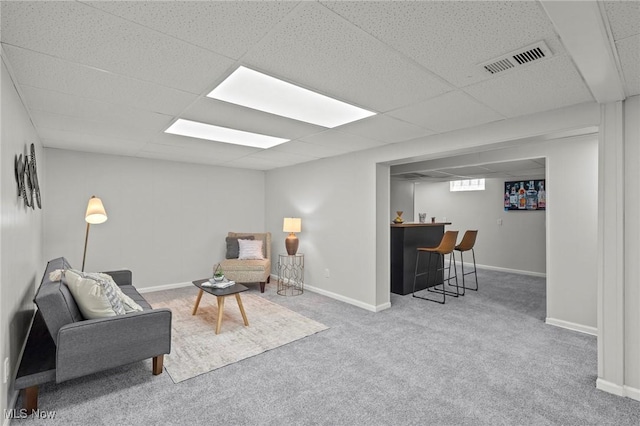 living area featuring visible vents, baseboards, bar, a paneled ceiling, and carpet