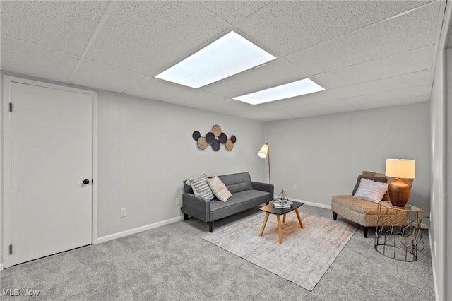 living room with baseboards, carpet flooring, and a drop ceiling