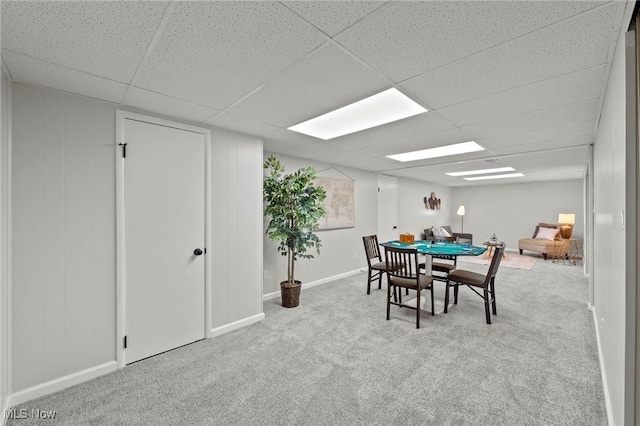 dining space featuring carpet floors, a paneled ceiling, and baseboards