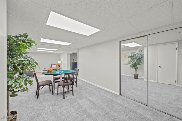 dining area featuring carpet flooring, baseboards, and a paneled ceiling